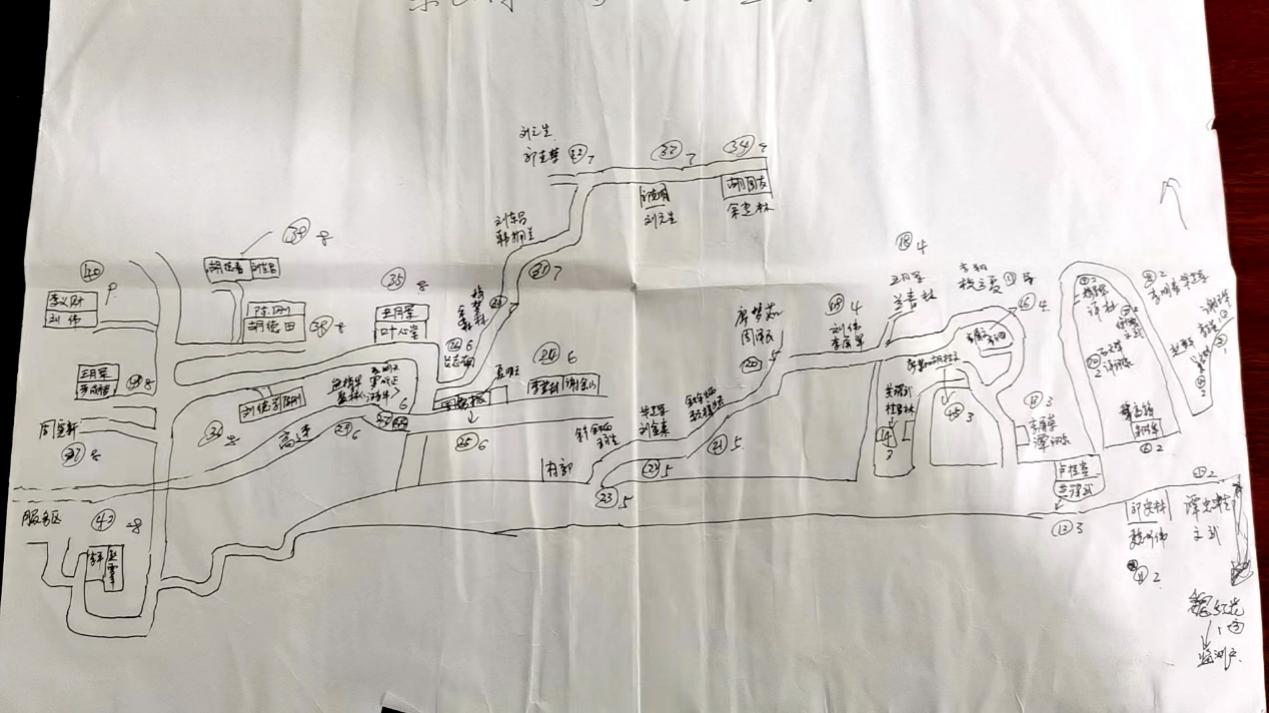 姚国生的手绘地图上,密密麻麻地记录着脱贫户人员信息。记者 邱烨摄。
